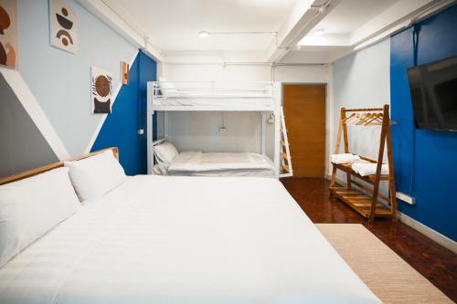 um quarto com uma cama branca e uma parede azul em Summer house em Chiang Mai