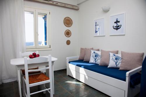 Zimmer mit einem Bett, einem Tisch und einem Fenster in der Unterkunft Aura Paros in Logaras