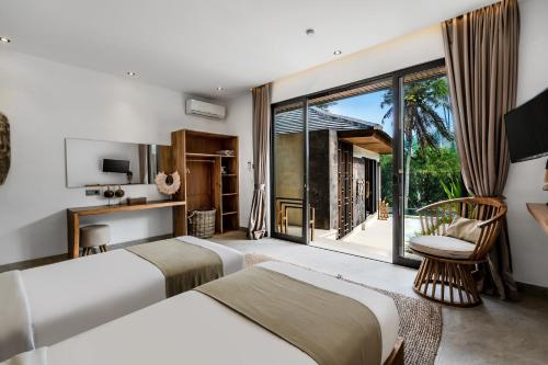 2 camas en una habitación con ventana grande en Villa Ganesha by BaliSuperHost, en Ubud
