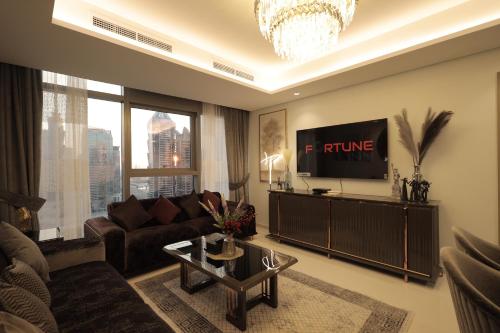 ein Wohnzimmer mit einem Sofa und einem TV in der Unterkunft PTR 3001-Lovely 1 Bedroom in Paramount Midtown in Dubai