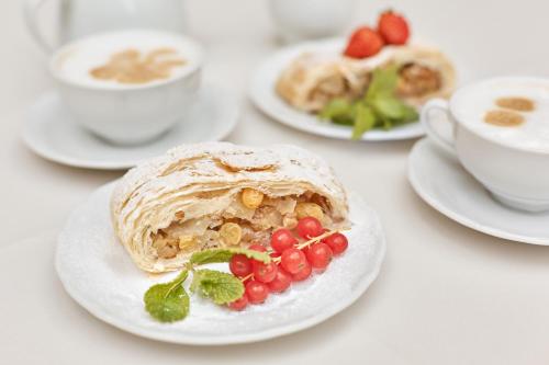 a table with plates of food and cups of coffee at Spa Hotel Villa Ritter in Karlovy Vary