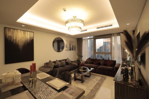 ein Wohnzimmer mit einem Sofa und einem Tisch in der Unterkunft PTR 3001-Lovely 1 Bedroom in Paramount Midtown in Dubai
