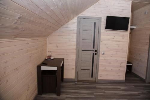 a room with a door and a desk and a television at Готель Бережани in Brzezhany
