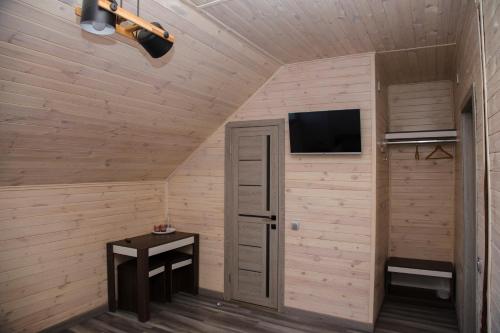 Zimmer mit einem kleinen Tisch und einem TV an der Wand in der Unterkunft Готель Бережани in Brzezhany