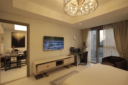 a living room with a television and a dining room at PTR 3001-Lovely 1 Bedroom in Paramount Midtown in Dubai