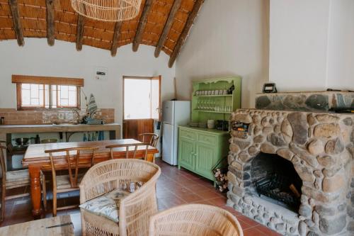 a kitchen and dining room with a stone fireplace at Audley End Farm in Curryʼs Post