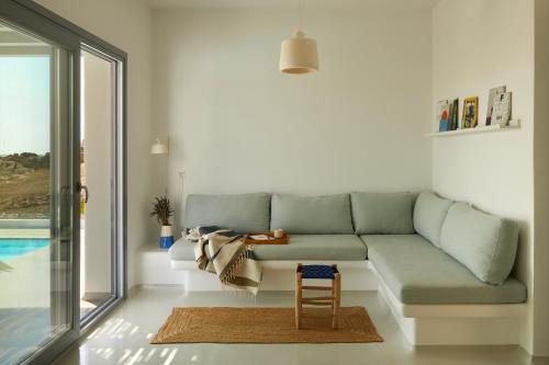ein Wohnzimmer mit einem Sofa und einem Stuhl in der Unterkunft Isychos House in Mikri Vigla