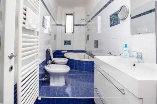 un bagno bianco e blu con servizi igienici e lavandino di HOME 41 con vista mare a Trieste