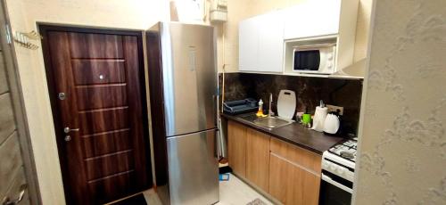 a kitchen with a stainless steel refrigerator and a sink at Центр кондиціонер 2 спальні після ремонту 2 поверх кондиціонер in Ivano-Frankivsʼk