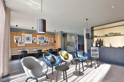 un vestíbulo con sillas, mesas y un mostrador en Hotel Garni Maximilian, en Dingolfing