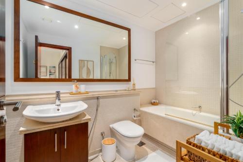 a bathroom with a sink and a toilet and a tub at Boutique Apartment Sea Views - Dubai Marina in Dubai