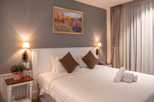 - une chambre avec un grand lit blanc et deux lampes dans l'établissement Thao Trang Laluxe Hotel Phu My Hung, à Hô-Chi-Minh-Ville