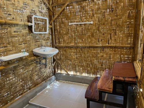 łazienka z umywalką i ścianą ze słomy w obiekcie Koh Mook Bungalows w mieście Ko Mook