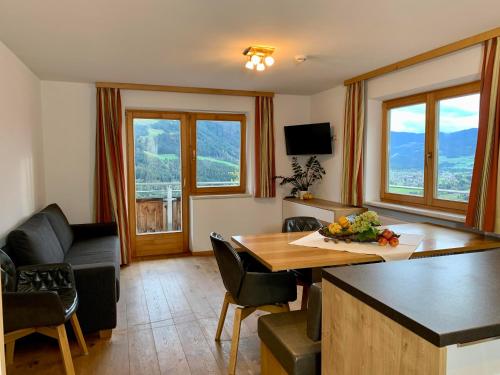 - un salon avec une table, des chaises et un canapé dans l'établissement Apartment Oberguggenhausen, à Brixen im Thale