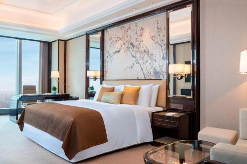 a bedroom with a large bed with a large window at The St. Regis Changsha in Changsha