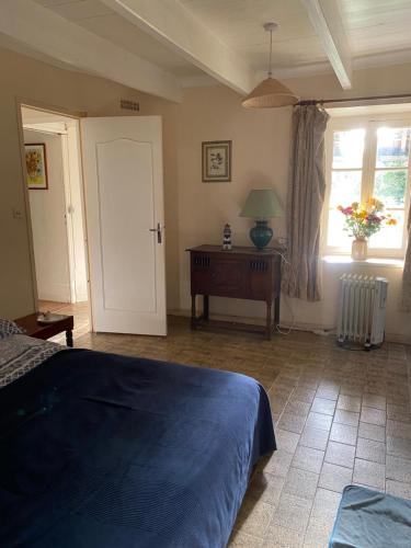 Schlafzimmer mit einem Bett, einem Tisch und einem Fenster in der Unterkunft cottage a la ferme in Lengronne