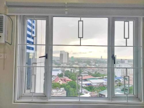 a window with a view of a city at Best Condo Studio within Limketkai Center in Cagayan de Oro