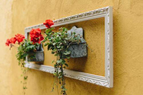 a mirror hanging on a wall with flowers on it at Mjällbyhus Pensionat & Stugby in Sölvesborg
