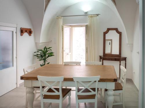 a dining room table with white chairs and a mirror at Lucente Rooms & Suites in Ugento