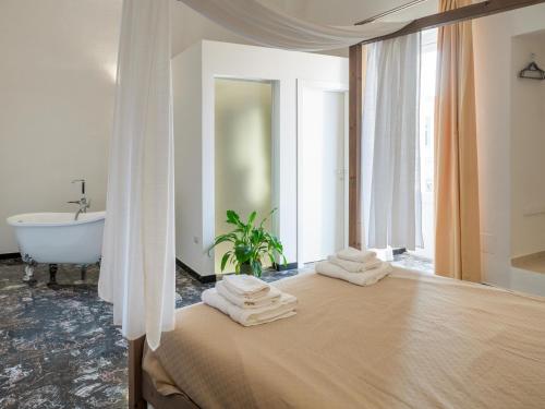 a bedroom with a bed with towels on it at Lucente Rooms & Suites in Ugento