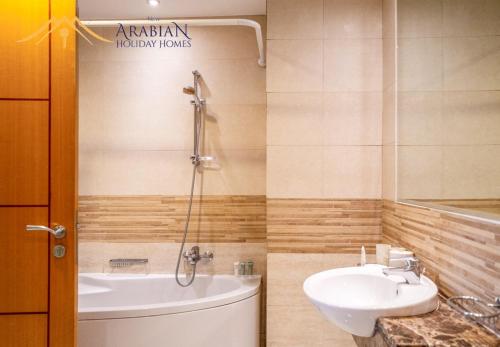 La salle de bains est pourvue d'un lavabo, d'une baignoire et de toilettes. dans l'établissement New Arabian Trident Waterfront Dubai Marina, à Dubaï