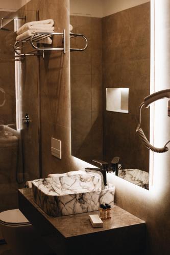 a bathroom with a marble sink and a shower at White Hill Hotel, SPA & Conferences in Durrës