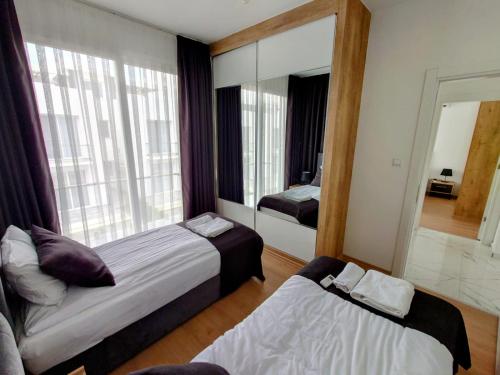 a bedroom with two beds and a large mirror at Luxury Four Seasons Life Sea Front Apartment 6-C in Boğaz