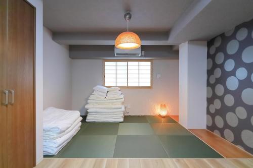大阪市にあるHOTALU Universal Vacation - Kanの床にタオルを積み重ねた部屋