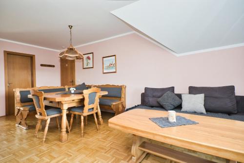 a living room with a table and a couch at Chalet Ferienwohnungen in Brennberg