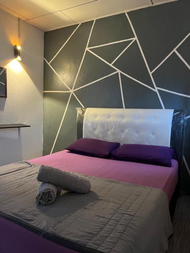 ein Schlafzimmer mit einem großen Bett mit lila Kissen in der Unterkunft JL Homestay Taman Pertama Satu in Lahad Datu