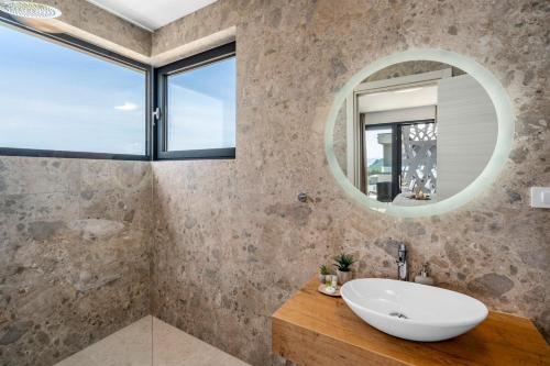 La salle de bains est pourvue d'un lavabo et d'un miroir. dans l'établissement NEW! Stylish Villa Olea with heated pool and panoramic sea views, à Podstrana
