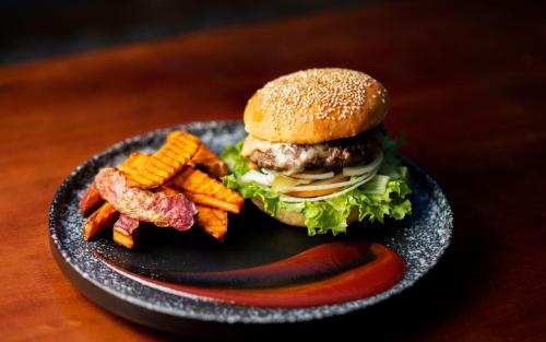 a plate with a hamburger and french fries on a table at Mad Monkey Hostel Siem Reap in Siem Reap