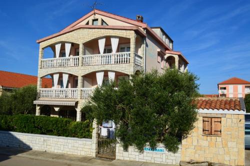 a house with a balcony on the side of it at Apartmani Nena in Povljana