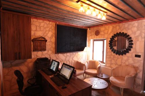 a room with two laptops on a desk and a chalkboard at Stone Owl Otel & Restaurant in Uchisar