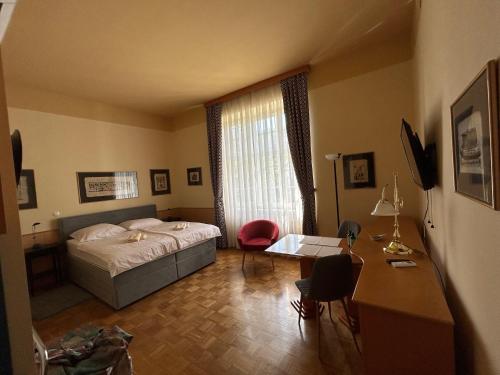 a bedroom with a bed and a table and a desk at Apartma Vila Golf in Rogaška Slatina