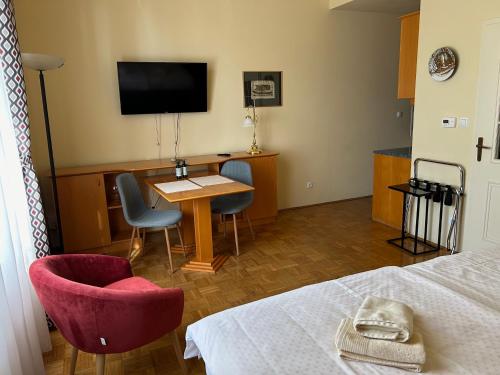 a room with a bed and a table and a tv at Apartma Vila Golf in Rogaška Slatina