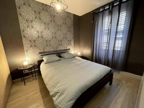 Un dormitorio con una cama grande y una ventana. en Le Cocon Savoyard, en Albertville