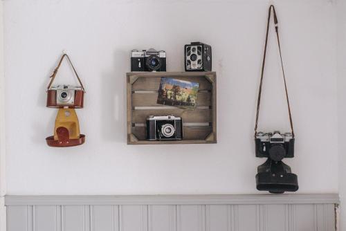a shelf with cameras and a mirror on a wall at Mjällbyhus Pensionat & Stugby in Sölvesborg