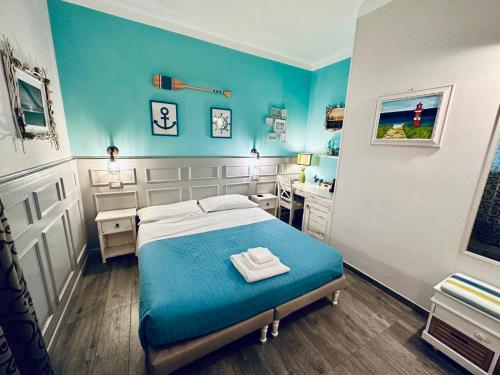 a bedroom with a bed with blue walls and a desk at AlCivico3 in Civitanova Marche