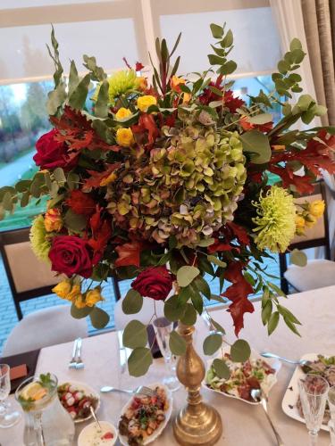 a vase with a large arrangement of flowers on a table at Villa Orchidea in Šakiai