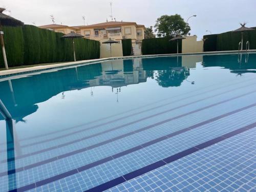 a swimming pool with blue water in a house at Playa Flamenca 2 bed Apt Sol De Mar in Villamartin