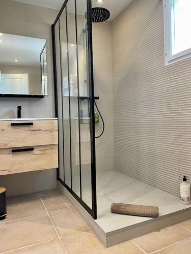 une douche avec une porte vitrée dans une salle de bain dans l'établissement Spacieux apt à proximité du port: clim et parking, à Bandol