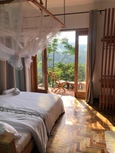 a bedroom with a bed and a large window at Baranko Villa in Fort Portal