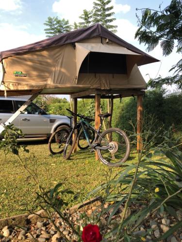 a bike parked in a tent next to a car at Baranko Villa in Fort Portal