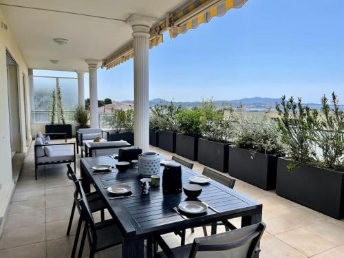un patio avec une table et des chaises sur un balcon dans l'établissement Spacieux apt à proximité du port: clim et parking, à Bandol