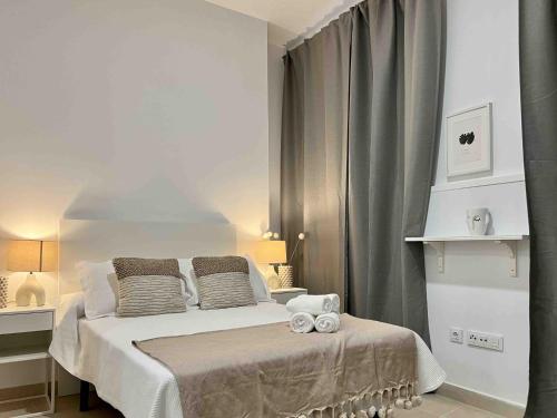 a bedroom with a bed with two towels on it at Apartamentos La Tahona in Cádiz