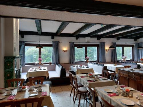 - une salle à manger avec des tables, des chaises et des fenêtres dans l'établissement Draxlerhaus, à Hohentauern