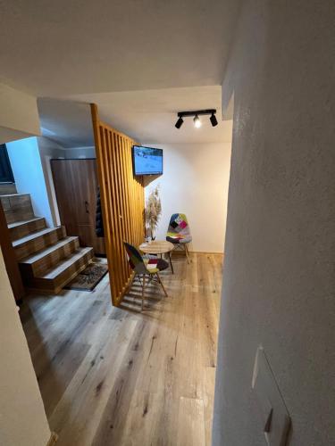 mit Blick auf ein Wohnzimmer mit einem Tisch und einer Treppe in der Unterkunft Tim apartment 1 in Timişoara