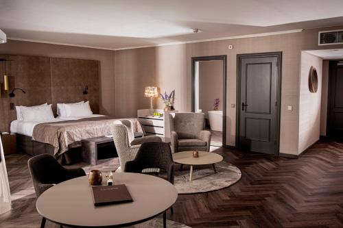 pokój hotelowy z łóżkiem, stołami i krzesłami w obiekcie Landgoed Lauswolt w mieście Beetsterzwaag