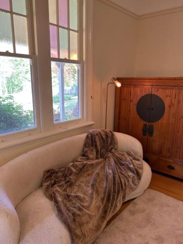 a living room with a couch with a blanket on it at Armidale Elegance in Armidale